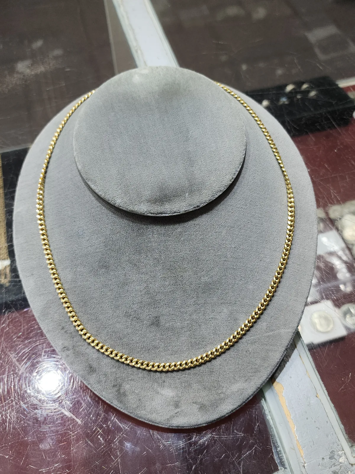 Solid gold Cuban link chain on a display bust